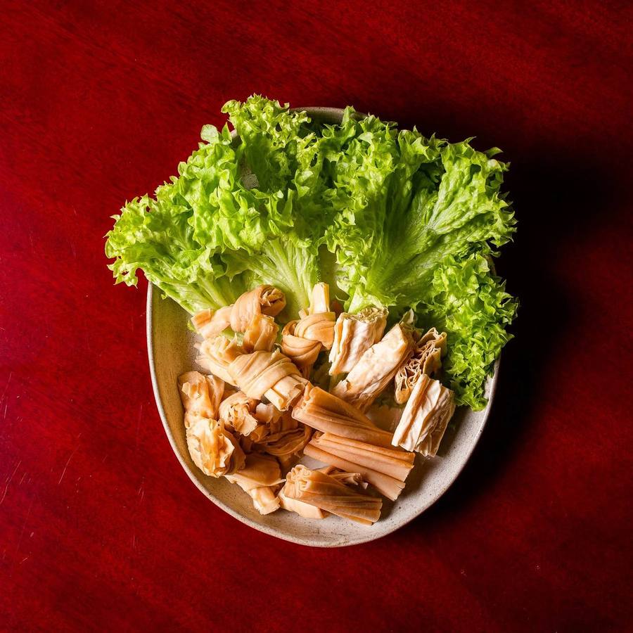 Teller mit Yuba-Knoten, Tofuhaut und Blattsalat für den Hotpot