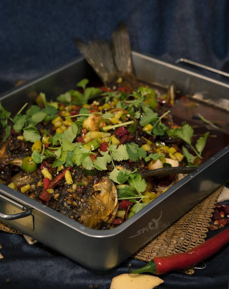 Gegrillter ganzer Fisch mit Chili, Koriander und eingelegten Paprika in der Servierpfanne