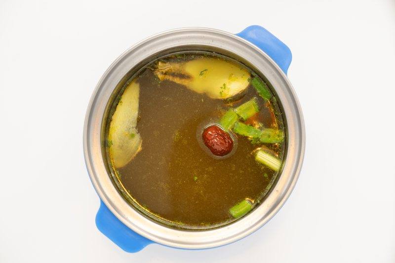 Klare Gemüsebrühe mit Frühlingszwiebeln und Jujube im Topf